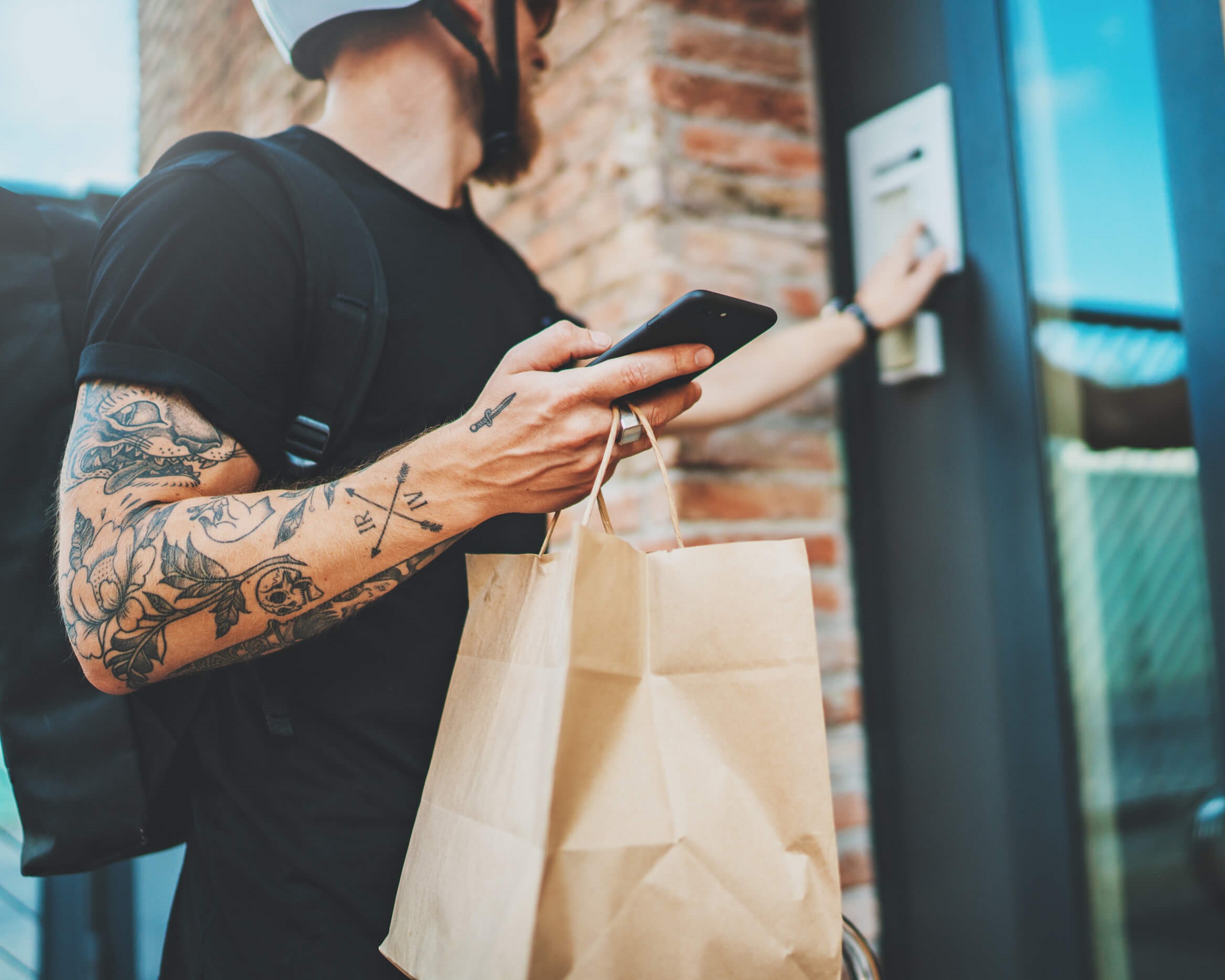 a delivery driver knocks on a door while holding a brown bag