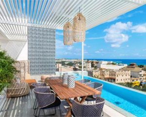 a dinner table near a pool, overlooking a beach-side town