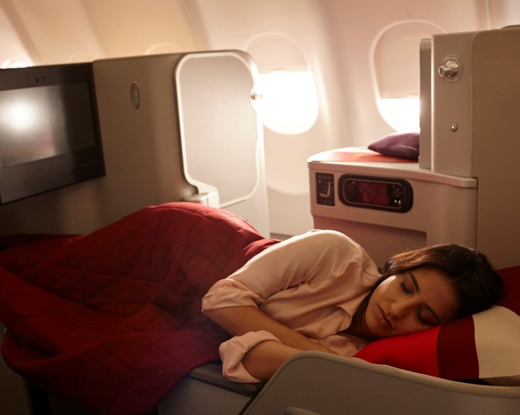 a woman sleeps in Iberia's business-class cabin