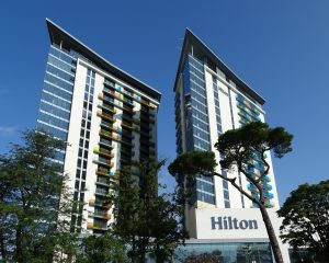looking up at 2 hotel towers with the Hilton logo on the side