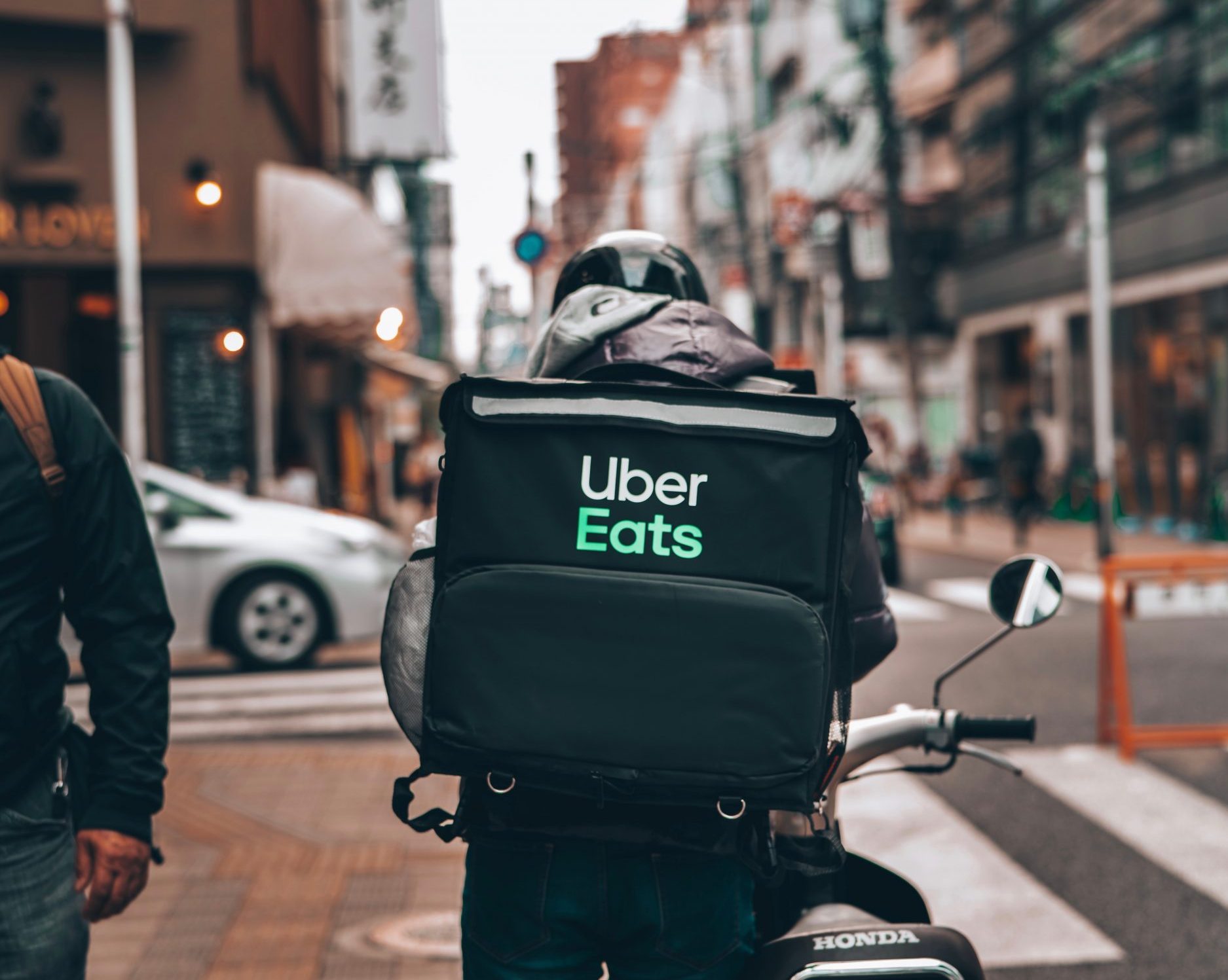 a moto delivery person with an Uber Eats delivery bag