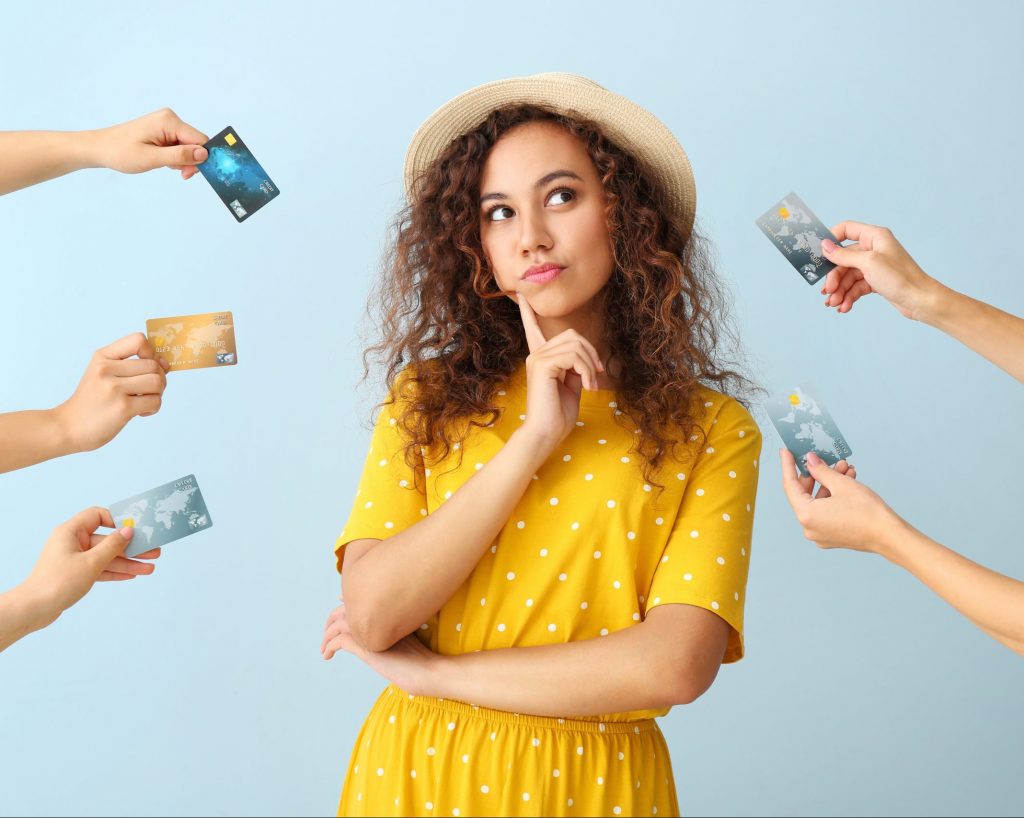 hands reach out offering credit cards to a person in the middle who is deep in thought