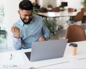 a man is excited about what he sees on his computer