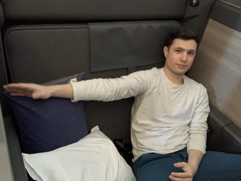 Passenger extending an arm to show how wide "THE Room" seat is.