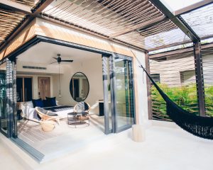 a hammock in front of an open sliding door at a luxury hotel