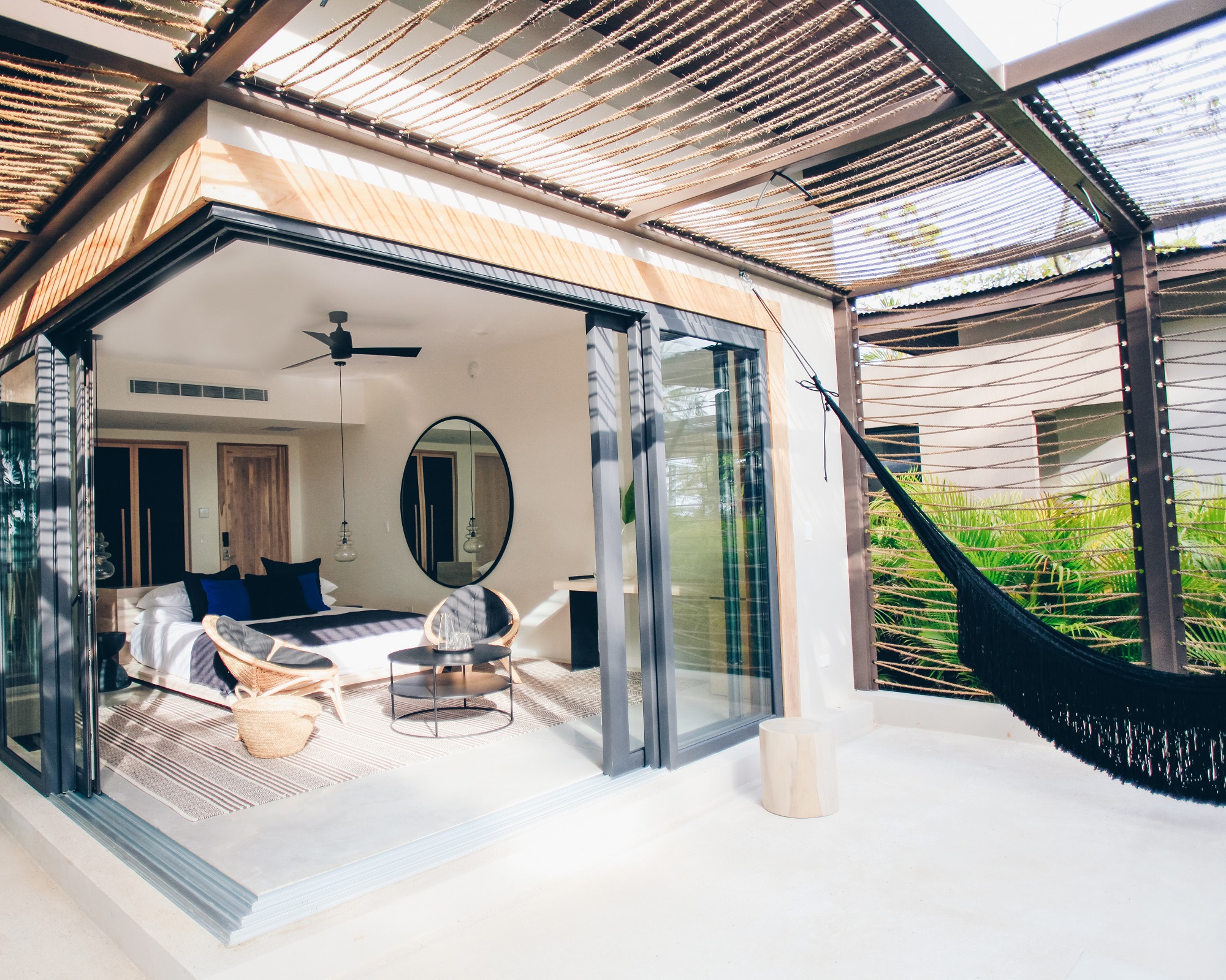 a hammock in front of an open sliding door at a luxury hotel