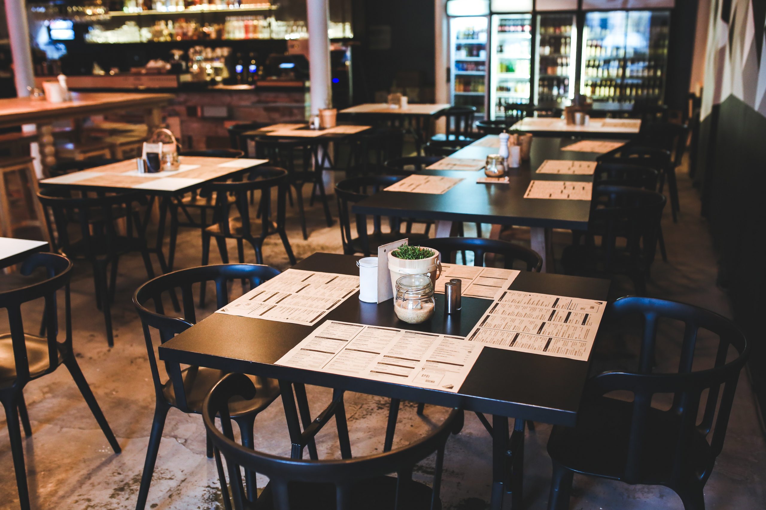 A restaurant with customer seating and table setting. Select Priority Pass members receive a food and beverage allowance at participating restaurants.