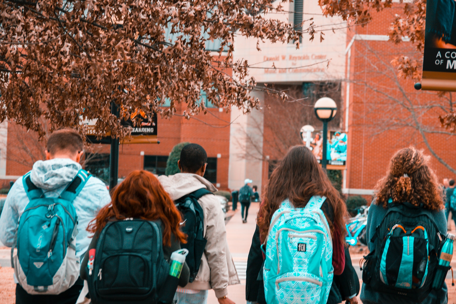 Students walk on a college campus. Students may be able to earn points and miles on college-related expenses with rewards credit card.