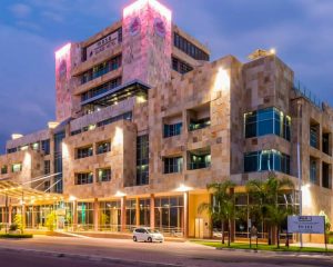 a multi-level stone block hotel is lit up at night