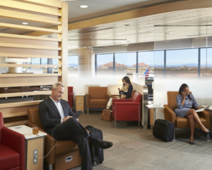 travelers sit inside an American Airlines Admirals Club, which we discuss for amenities and access rules