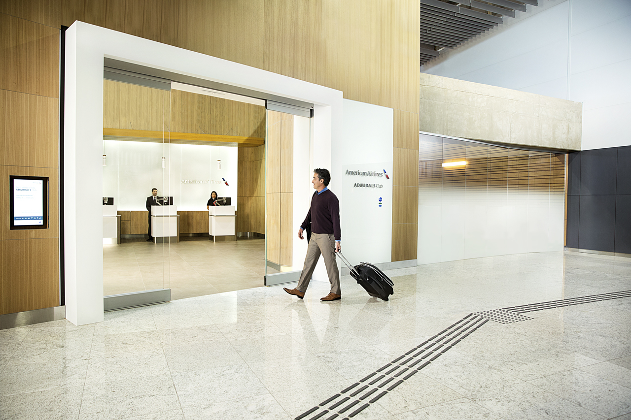 American Airlines Admirals Club entrance with passenger entering the lounge.