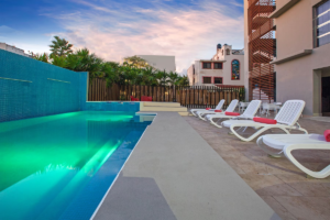 a pool and deck chairs at a hotel