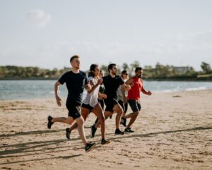 a group of people running on a beach