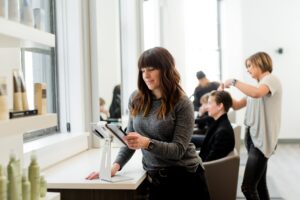 Small business woman using a card portal in a hair salon