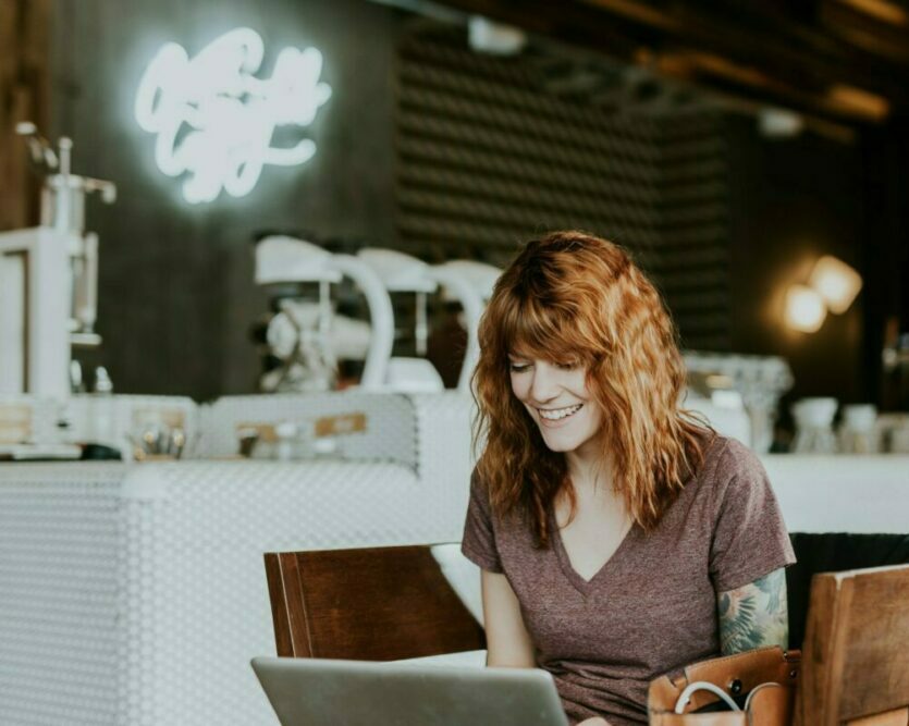 Woman sitting in cafe with laptop on table