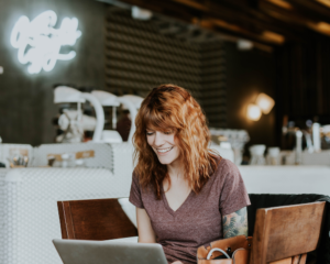 a woman uses a laptop in a cafe