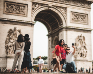 a family takes a selfie together in front of a giant arch