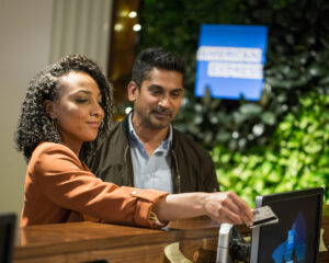 a couple shows ID at the check-in desk for an American Express Centurion Lounge