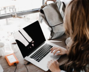 a woman uses her laptop to search for information while inside a coffee shop