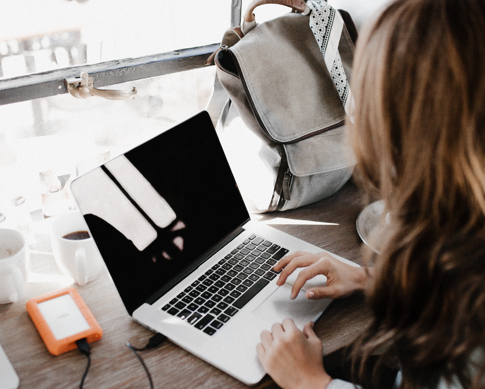 a woman uses her laptop to search for information while inside a coffee shop