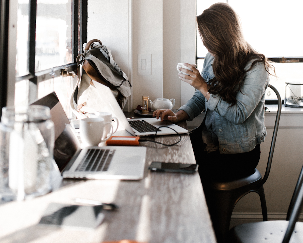 a woman at a coffee shop using a laptop