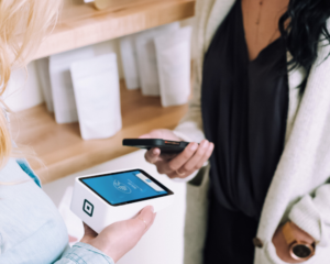 a customer pays by mobile wallet inside a small shop