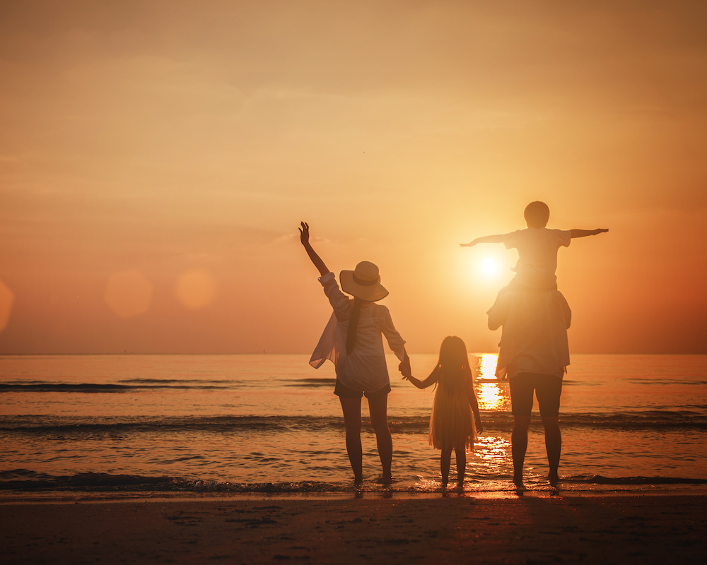 a family on a beach at sunset