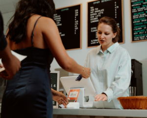a customer pays by credit card at a small cafe