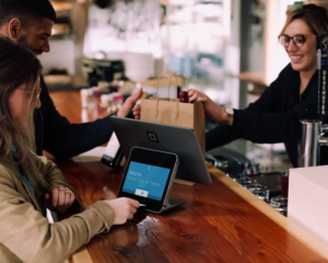 people pay by credit card for a bag full of wine bottles