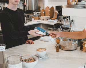 a customer pays by credit card at a coffee shop