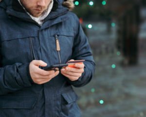 a person looks at a smart phone while holding a credit card