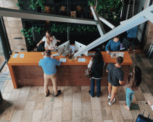 overlooking a hotel reception desk with multiple guests and employees