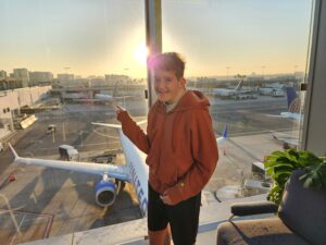 a child inside an airport points to the plane at the gate