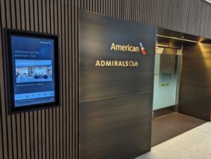 Entrance of the Newark Admirals Club with a display showing the operating hours