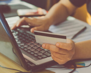 woman hand holding credit card and using laptop making online payment online, online shopping