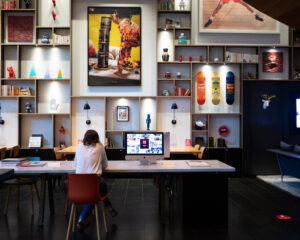 someone working at a desk in a hotel lobby full of art