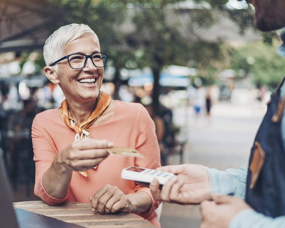 a person pays by credit card at an outdoor café