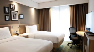 Two beds and desk in a room at the Hampton By Hilton Dortmund Phoenix See.