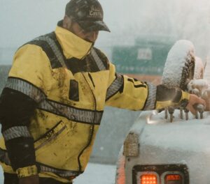 a driver operates a tow truck in the snow