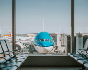 a KLM plane parked at a gate, seen from inside the airport's windows