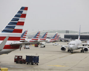 American Airlines planes and tail fins at a busy airport