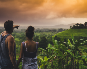 a couple looks over rice fields at sunrise