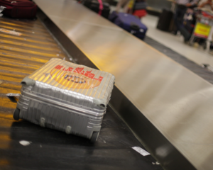 a suitcase moving on the baggage carousel at an airport's baggage claim area