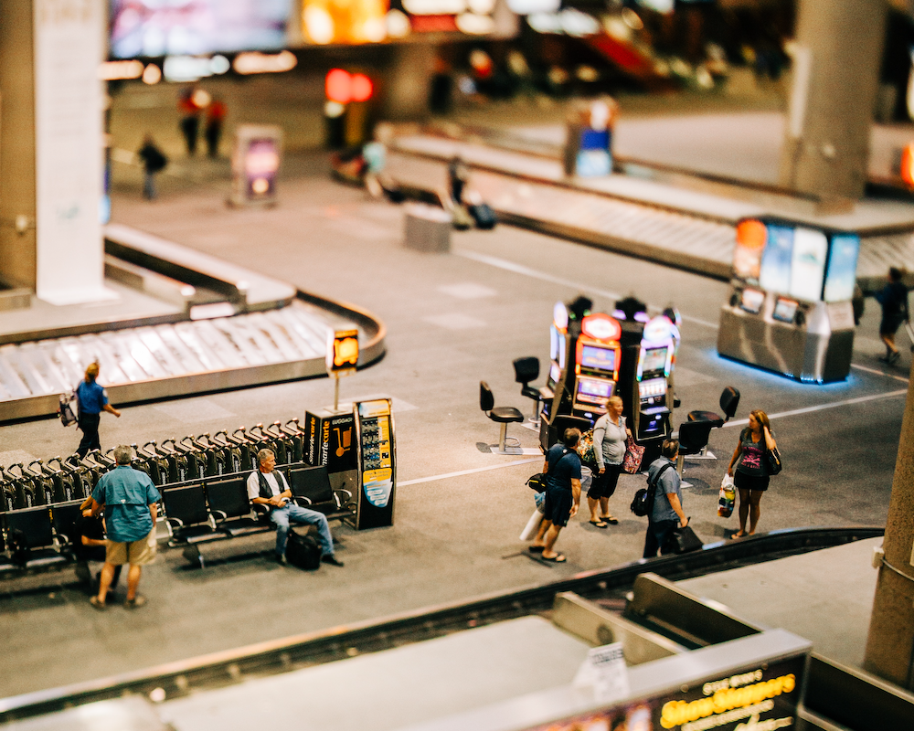 looking down at a busy baggage claim hall at an airport