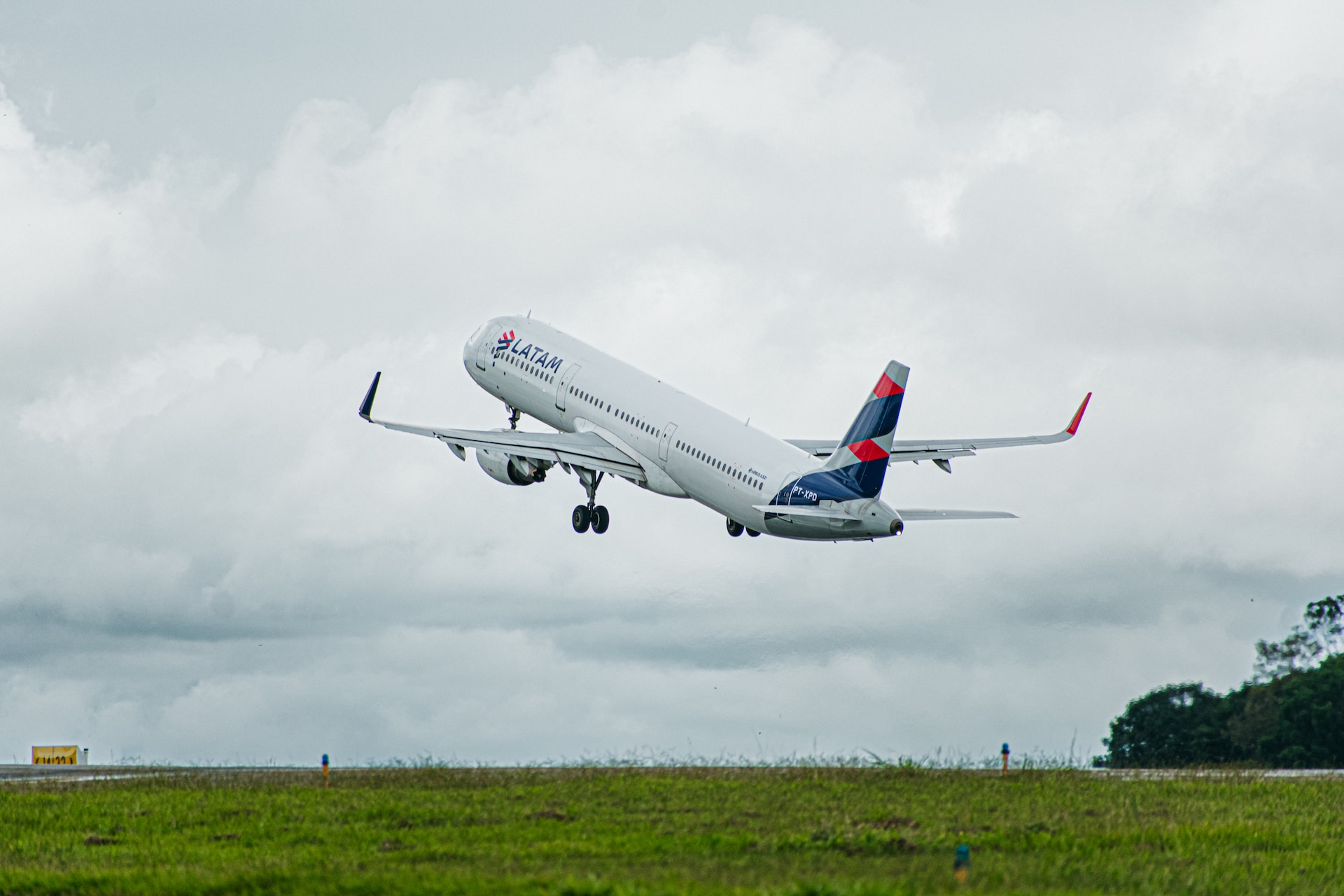 LATAM A320 taking off with a dark backdrop.