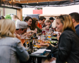 friends dine together at a long table at a restaurant