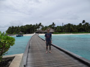 a man stands on the raised walkway to the W Maldives property