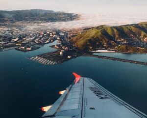 an Avianca plane wing seen from the plane window while flying over San Francisco