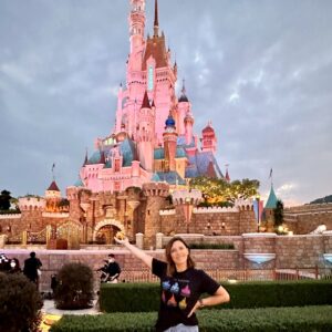 Samantha Holland in front of the Hong Kong Disney castle