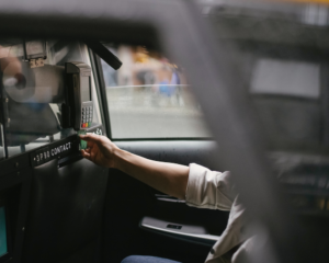 a hand inserts a credit card into a payment machine inside a taxi